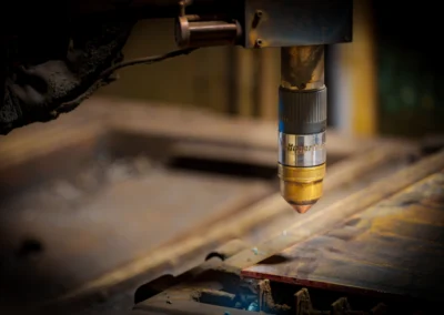 Close-up of a laser cutting machine head over metal surface