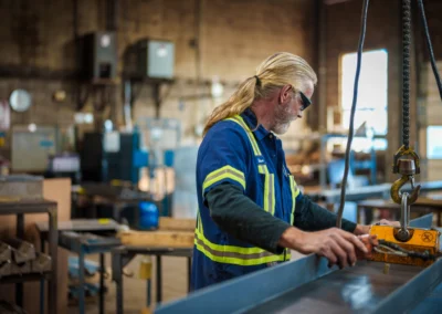 Worker in hi-vis gear operating machinery in an industrial workshop